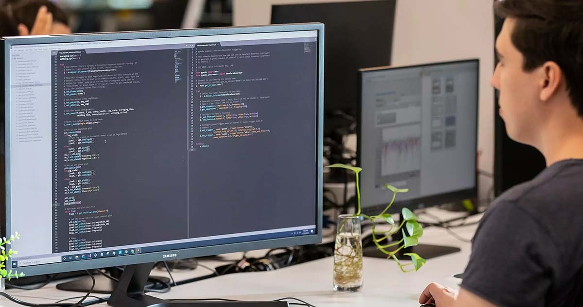 Engineer working at a desk writing a script to automate his tests.